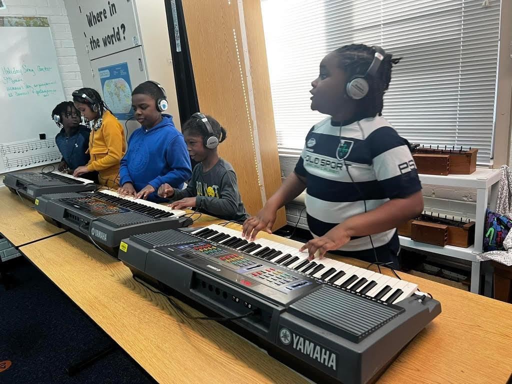 Students in the Music Club learning to play the keyboards